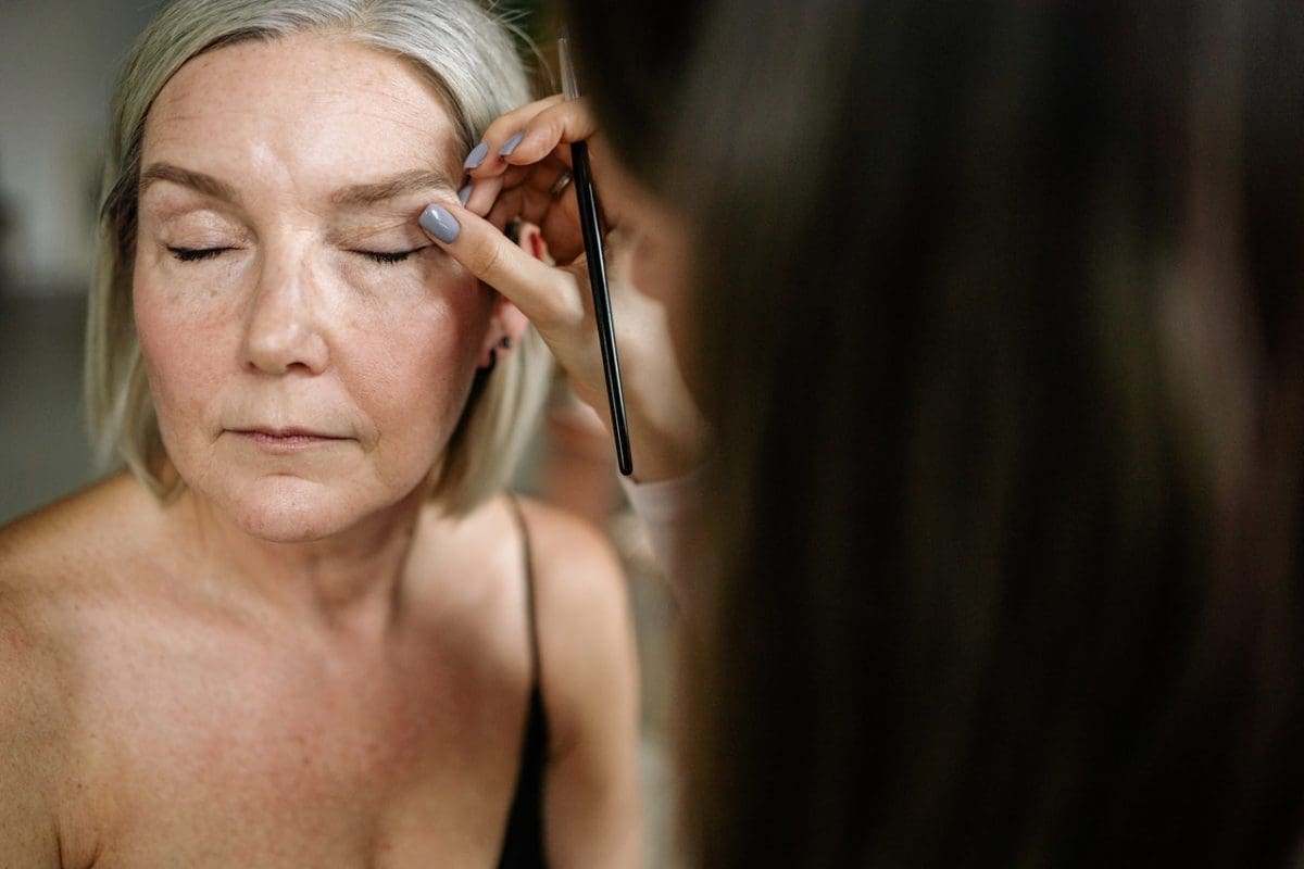 elderly woman getting her makeup done